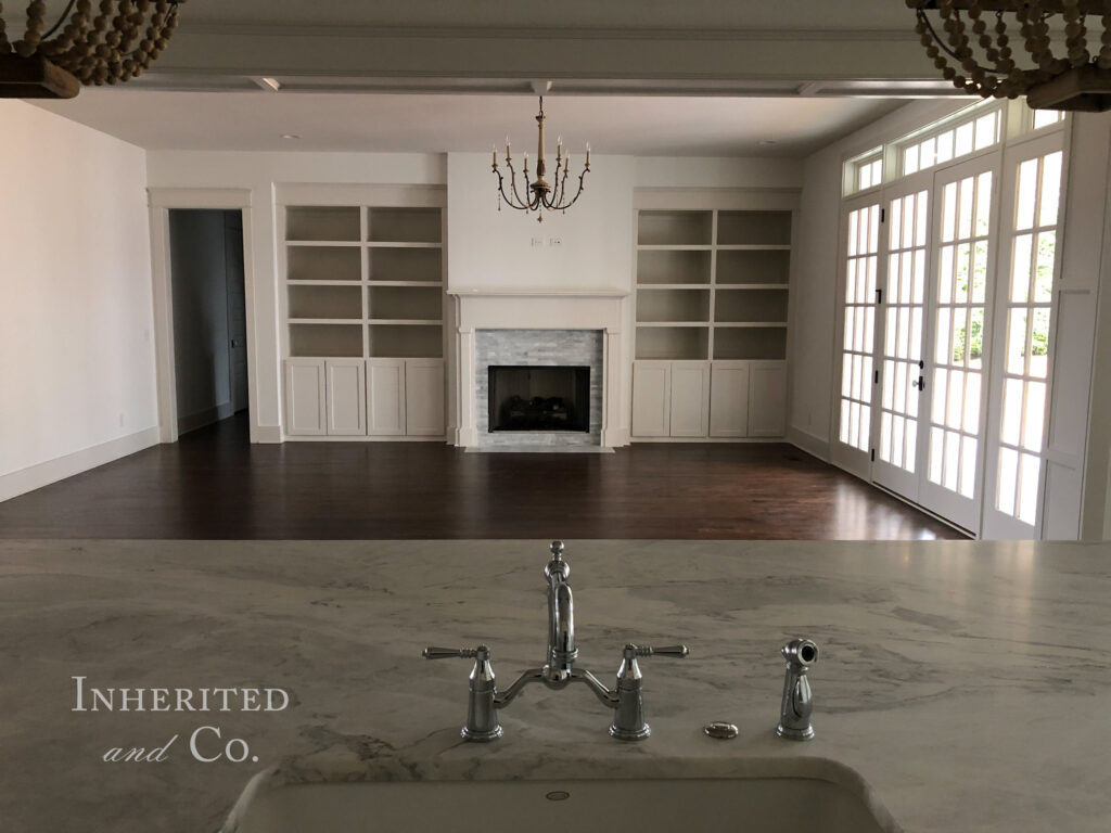 View from marble kitchen island and kitchen sink into empty custom built home