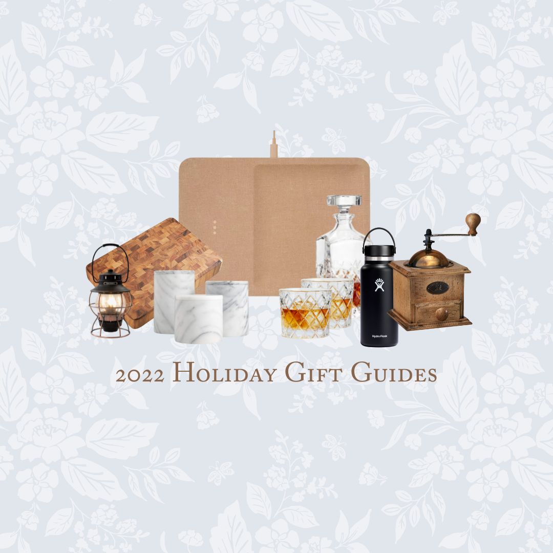 Graphic with pale blue floral background that reads "2022 Holiday Gift Guides" and features a collage of items, such as lantern, cutting board, marble canisters, electric phone charging pad, decanter and two rocks glasses, a water canteen, and a wooden coffee grinder