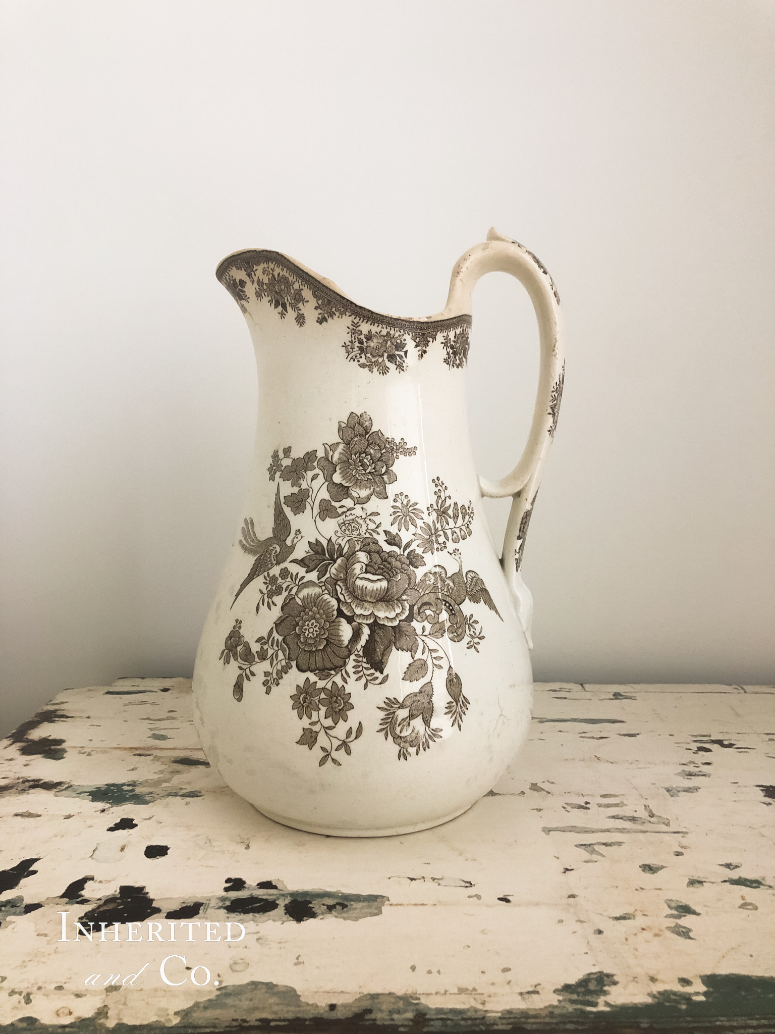brown transferware pitcher on chippy white surface
