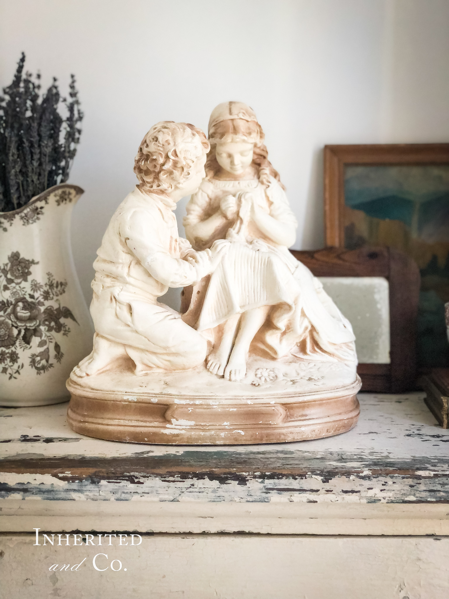 Vintage French sculpture in foreground of an antique vignette