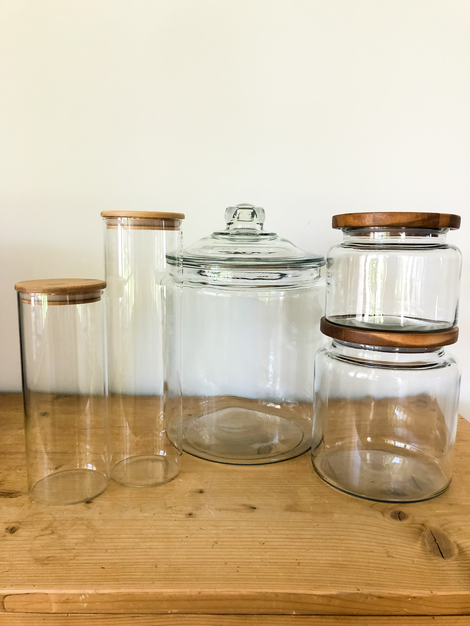 Five glass jars, four with wooden lids