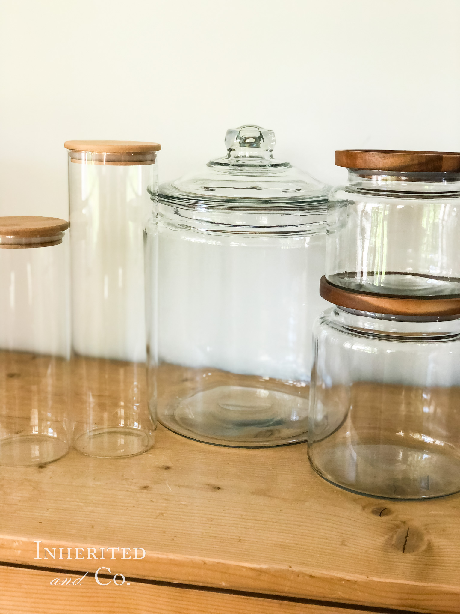 Five glass jars on top of a pine cabinet