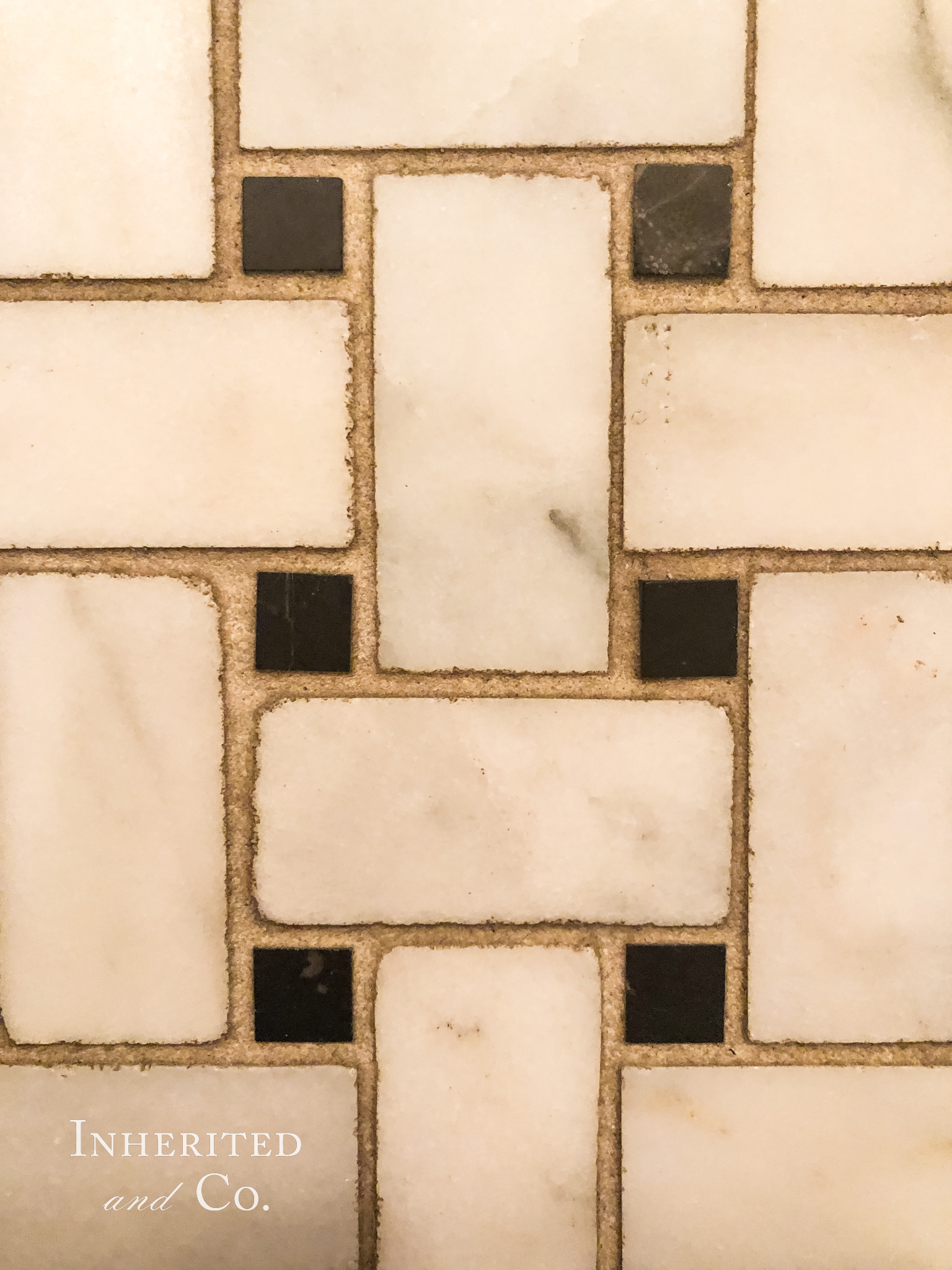 Close-up of basketweave marble tile with dirty grout