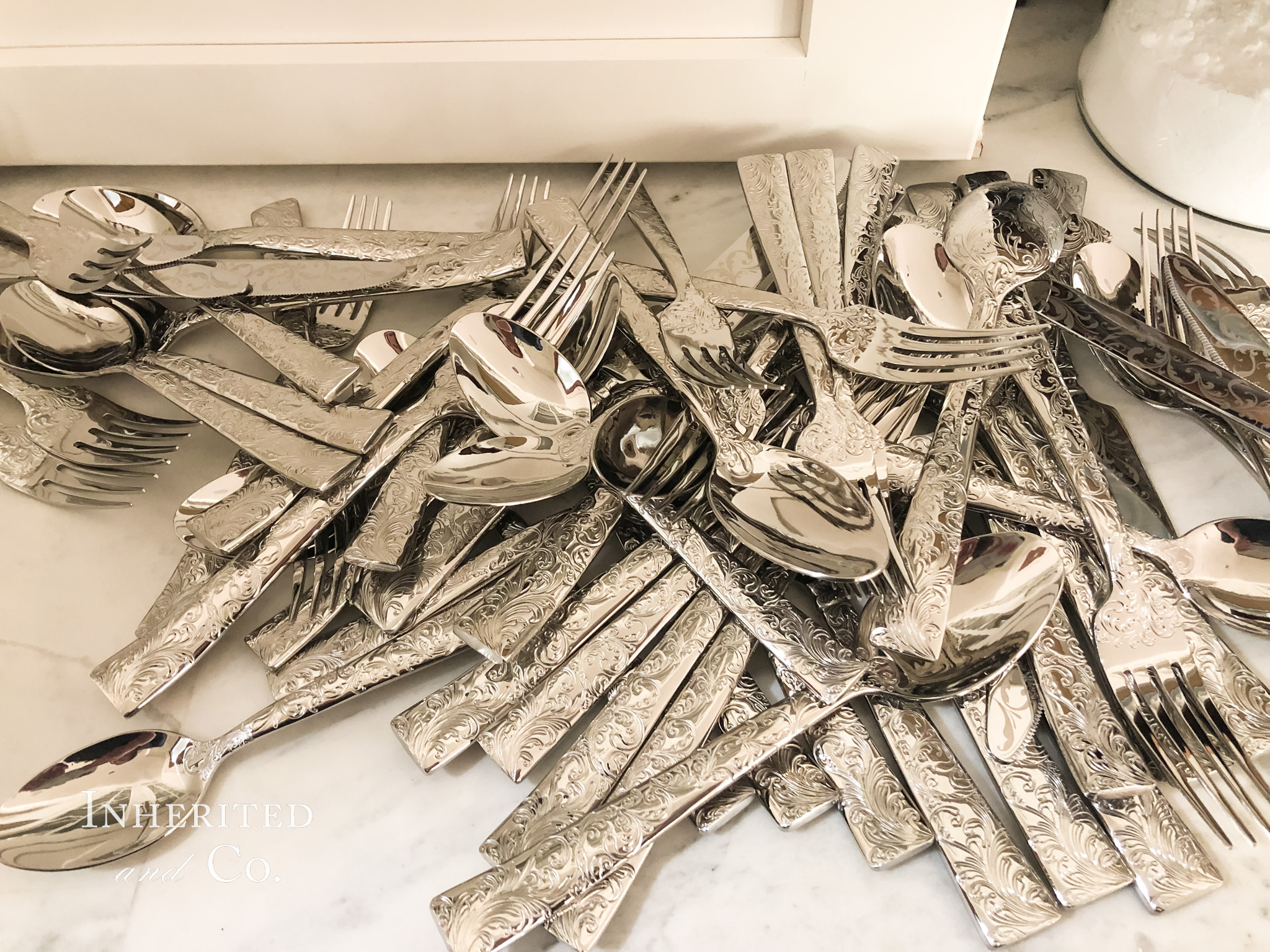 etched silverware in a pile