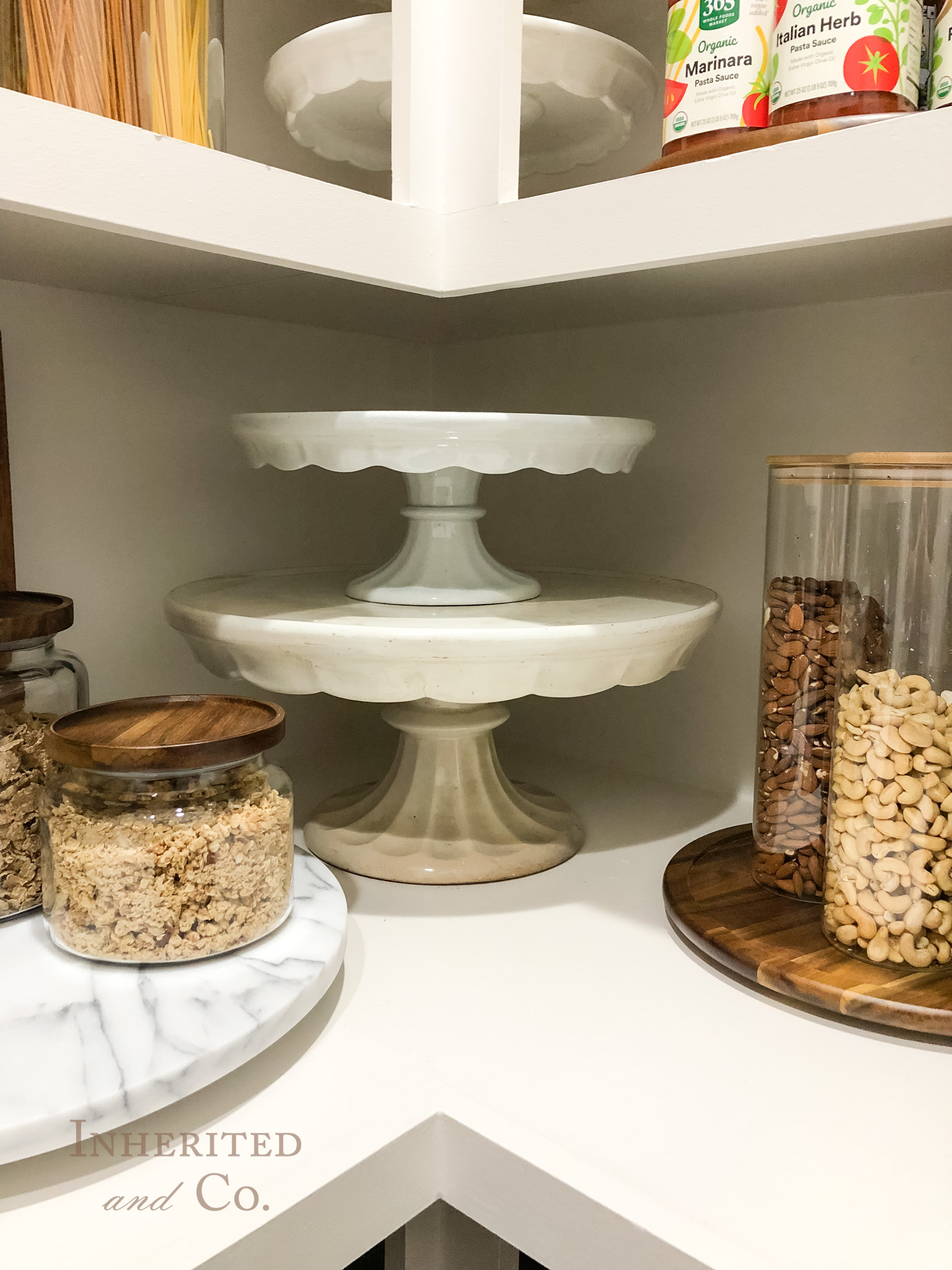 stack of antique ironstone cake stands in an organized pantry