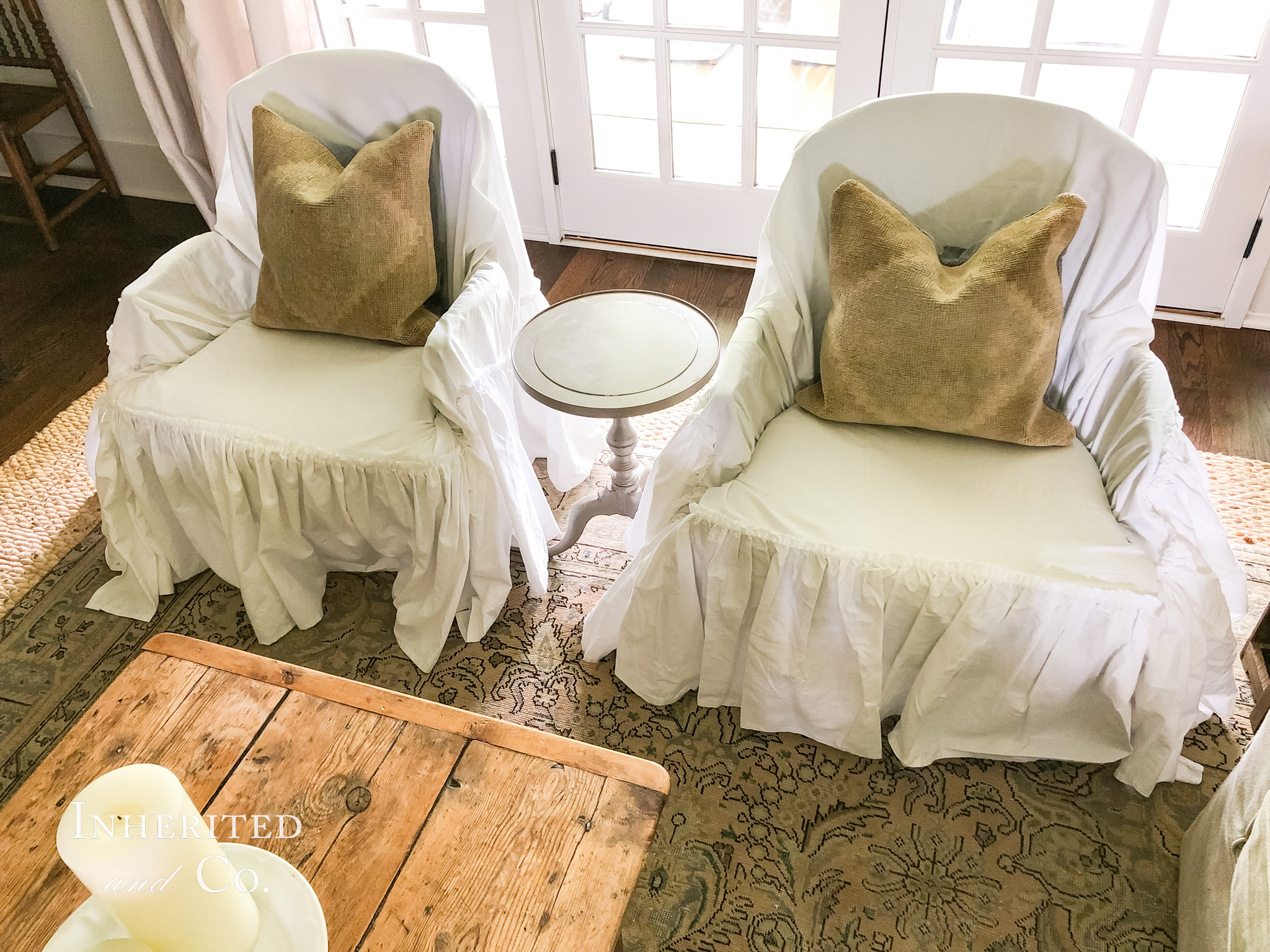 Pair of chairs with unfitted and ruffled white slipcovers