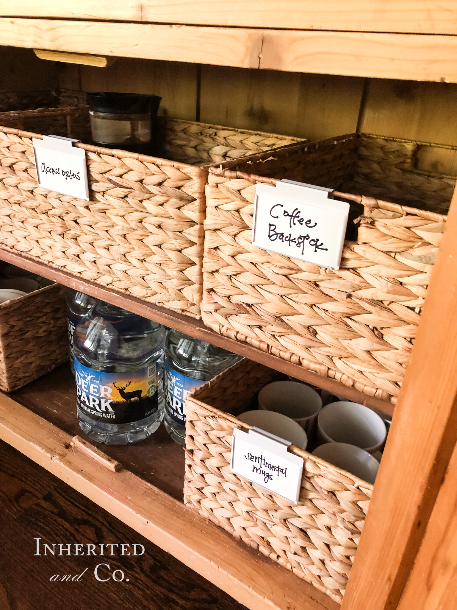 Baskets filled with coffee backstock and sentimental mugs in an antique cabinet home coffee bar