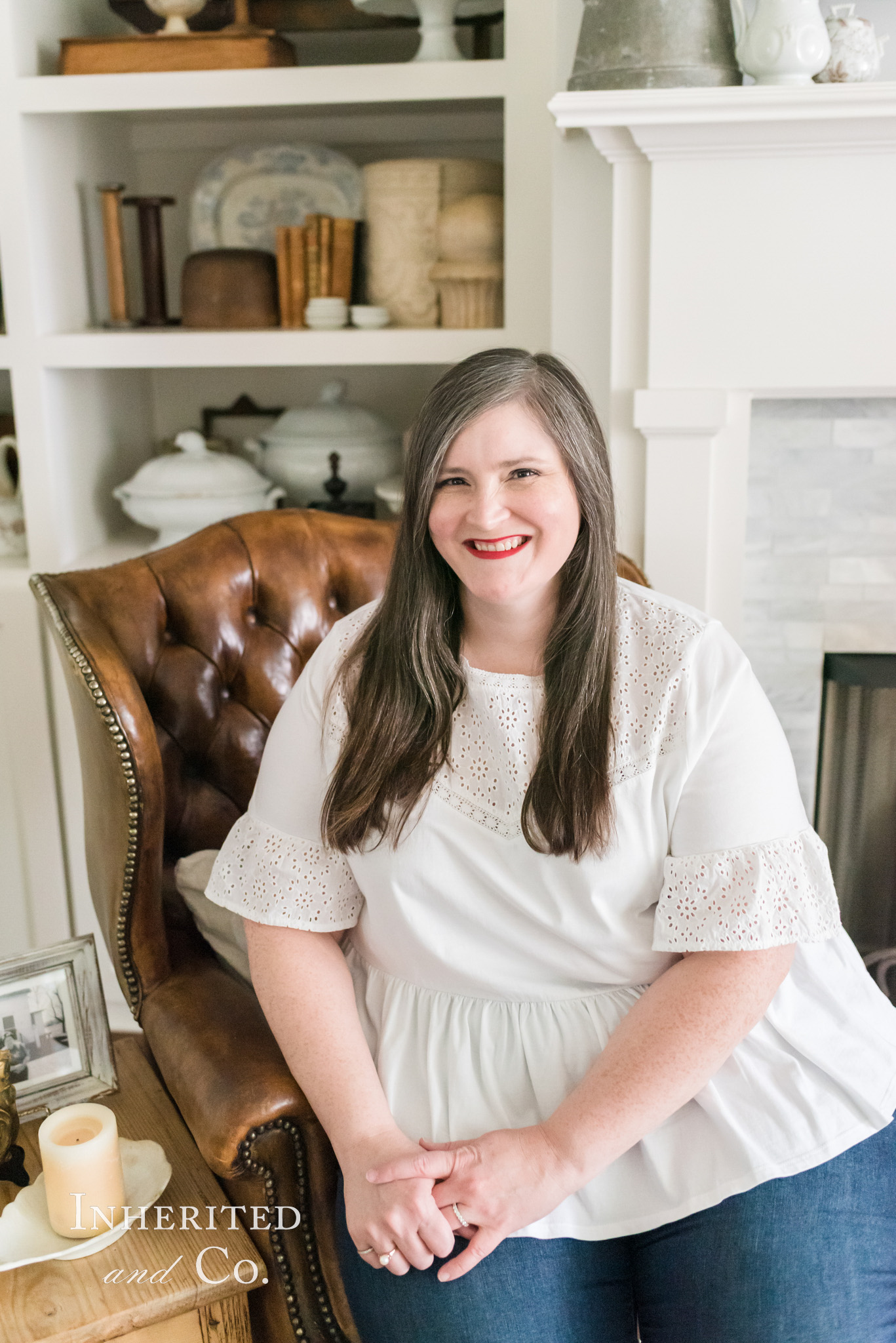 Lauren of Inherited and Co. sitting in a leather chair and surrounded by antiques