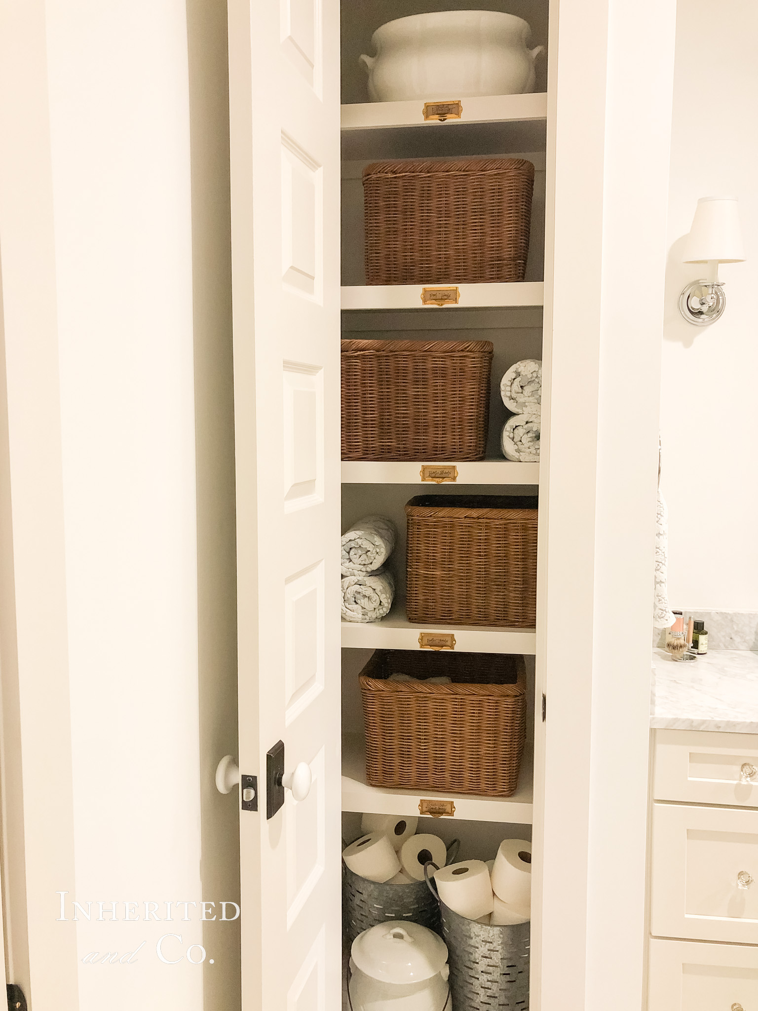 Towel Closet Organization featuring rattan baskets, antique ironstone, and card catalog labels