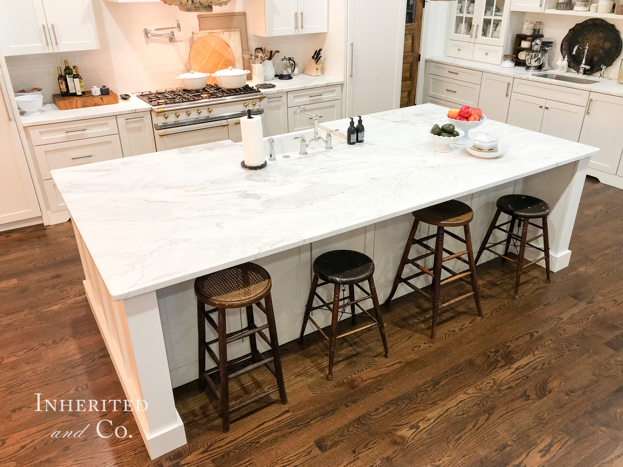 Marble-topped kitchen island with antique stools
