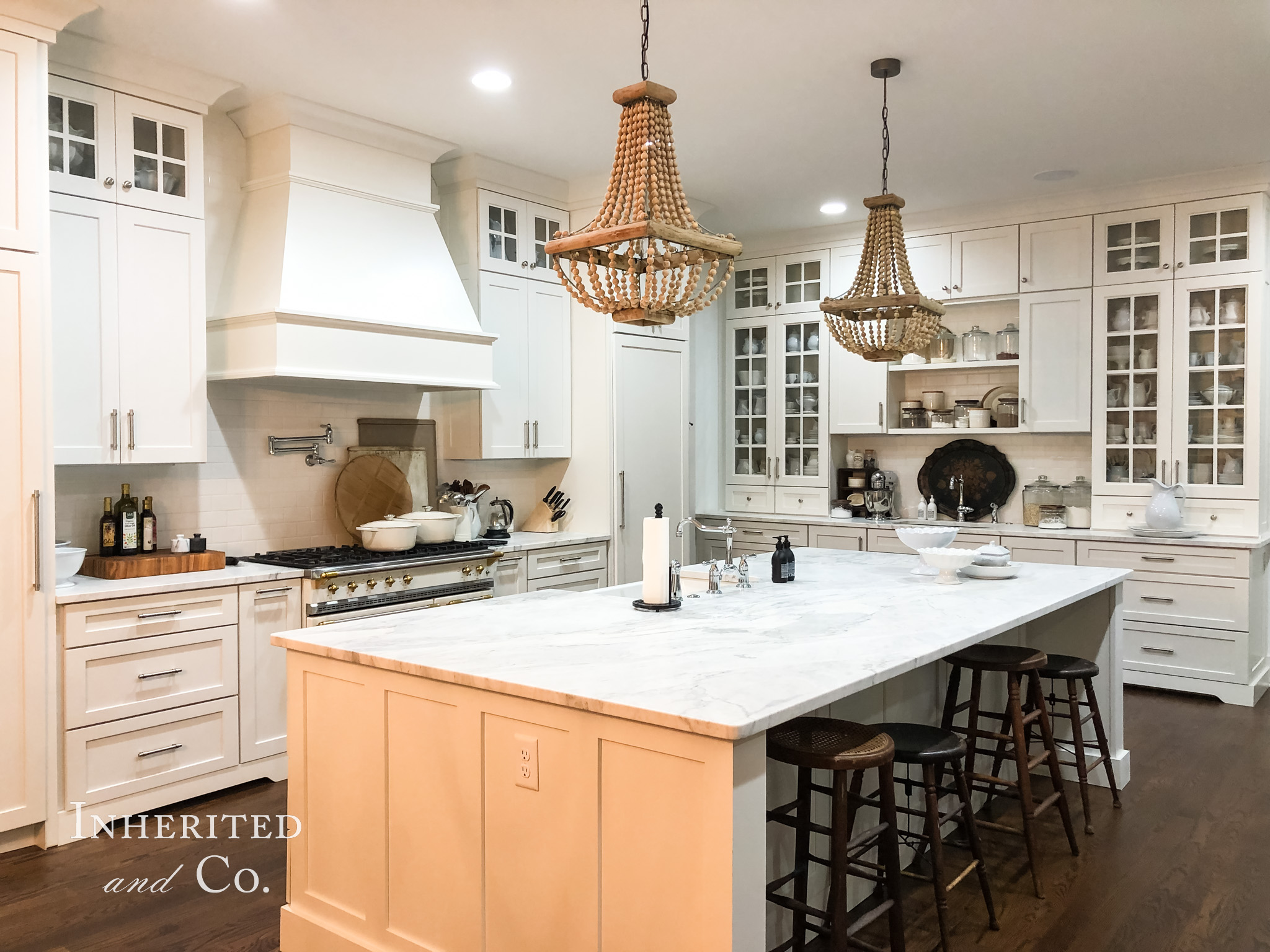 Custom Kitchen with white cabinets, marble countertops, French range