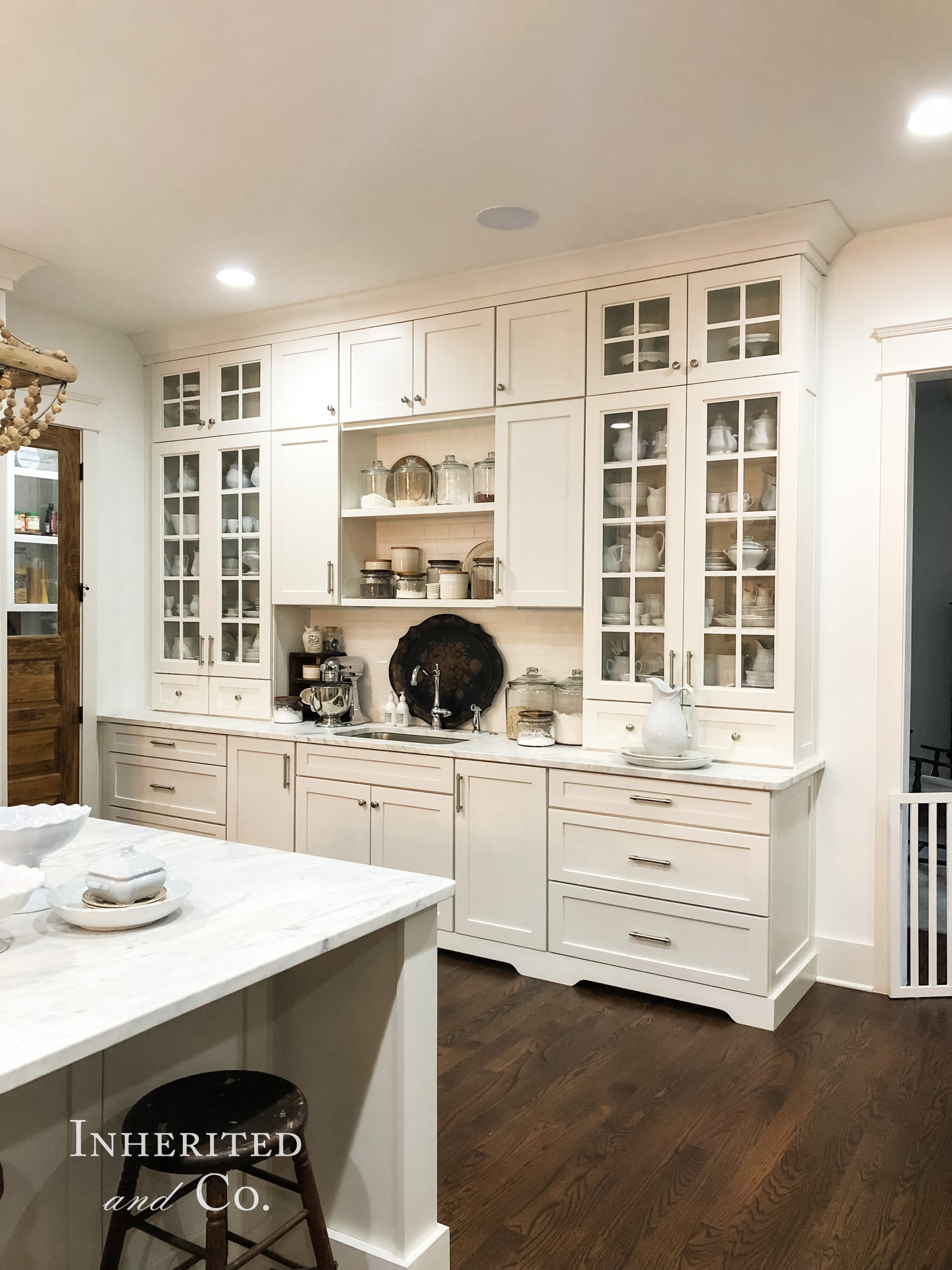 Bank of White Cabinets filled with antique ironstone and baking supplies