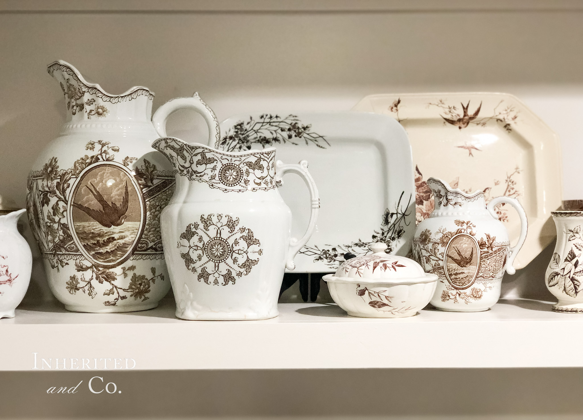 A collection of antique brown transferware made manageable by displaying on one bookshelf only